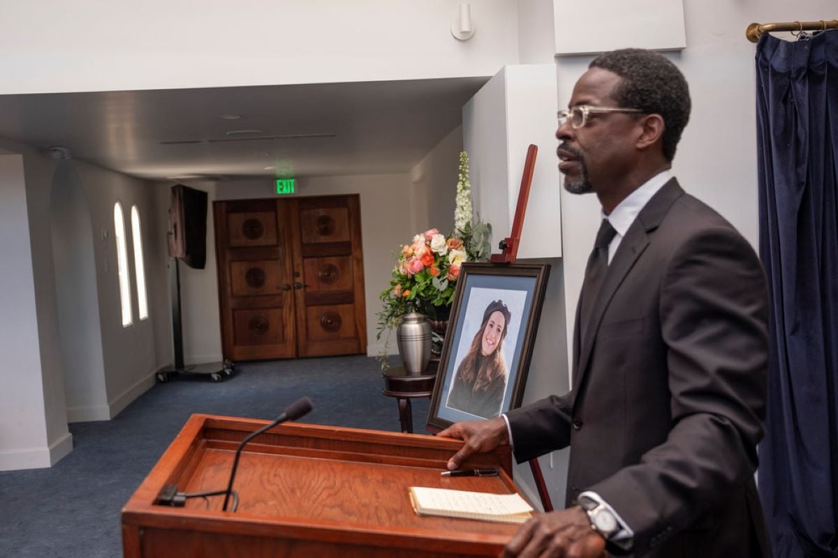 Sterling K. Brown, in character as Randall Pearson in 'This Is Us' Season 6 Episode 18, wears a black suit while speaking at a podium during Rebecca's funeral.
