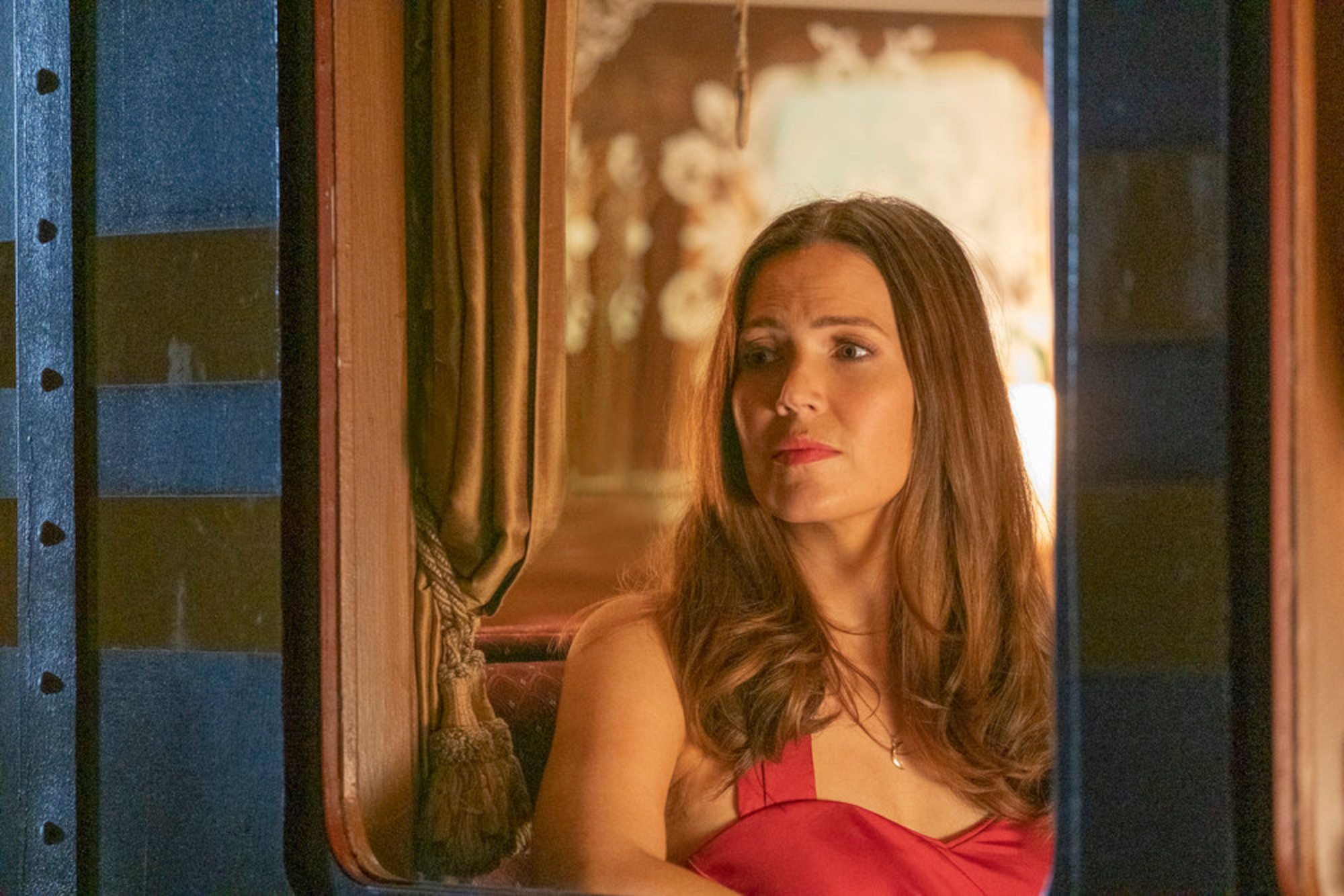 Mandy Moore as Rebecca Pearson in 'This Is Us' Season 6 Episode 17. Her funeral will take place in 'This Is Us' Season 6 Episode 18. She's on a train here, wearing a red dress.