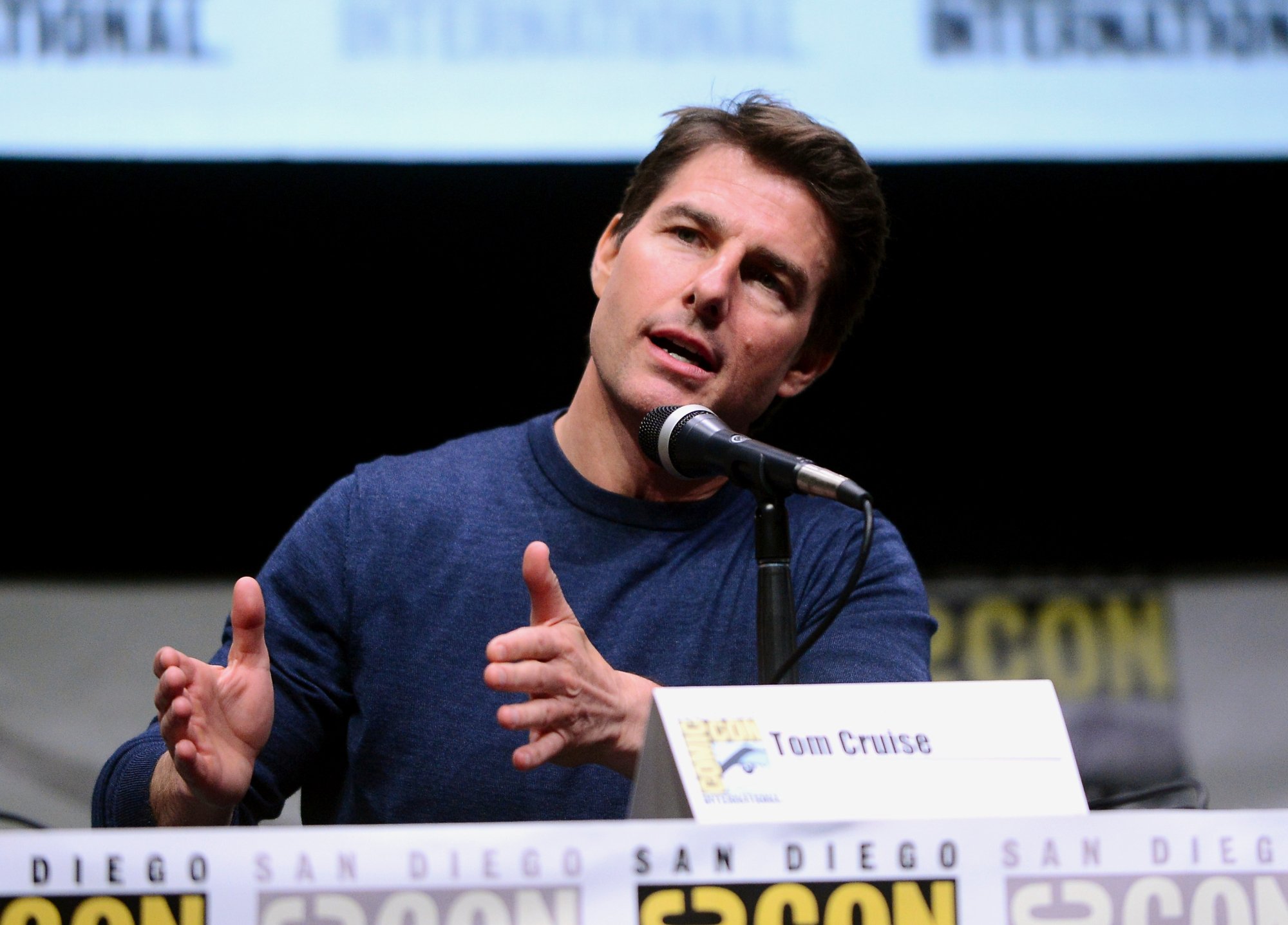 Tom Cruise, the ex-husband of Nicole Kidman, at Comic-Con speaking into the microphone with his hands over the table