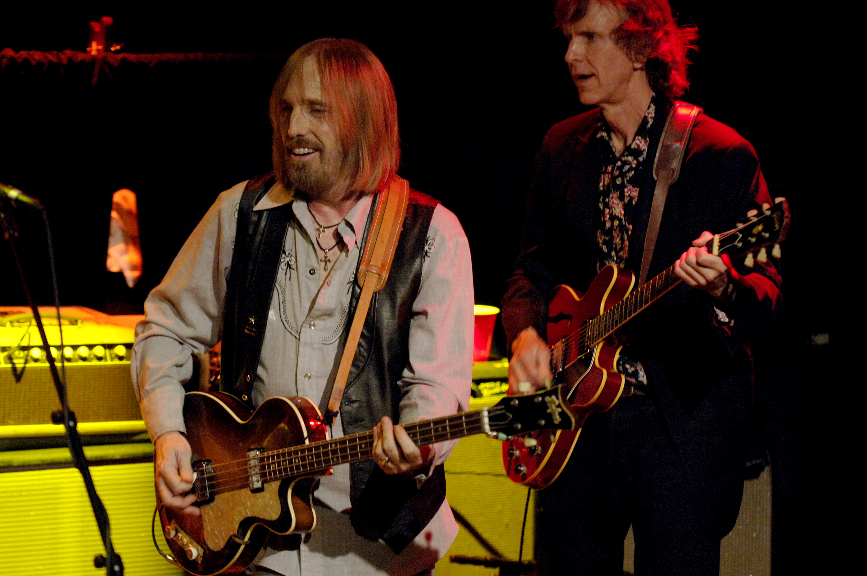 Tom Petty and his friend Tom Leadon play guitar together on stage.