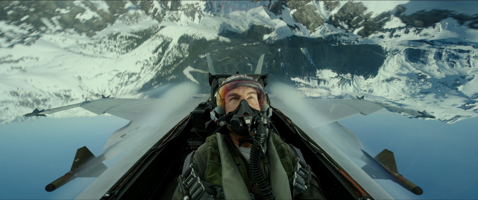 'Top Gun: Maverick' Tom Cruise as Maverick in jet with a helmet on, looking up toward the ground while inverted
