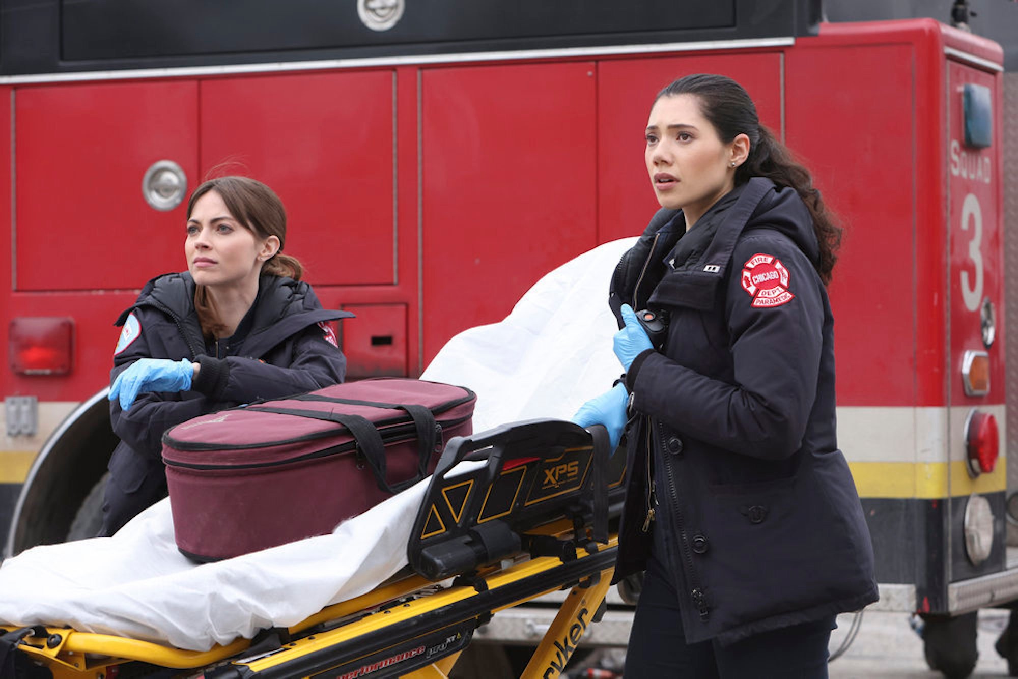 Emma Jacobs and Violet Mikami next to a stretcher in 'Chicago Fire' Season 10 Episode 20