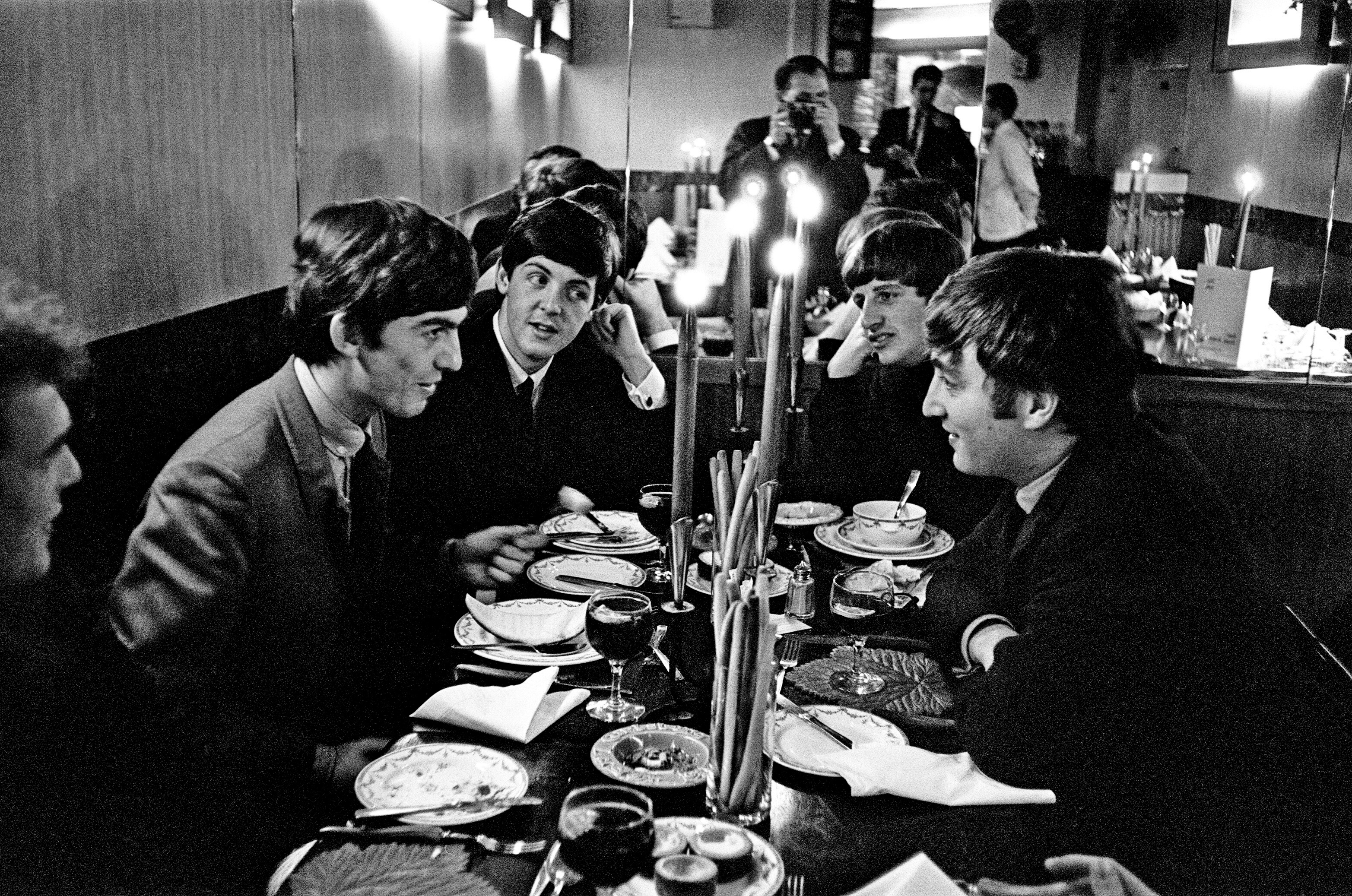 The Beatles' George Harrison, Paul McCartney, Ringo Starr, and John Lennon at a table during the "Yesterday" era