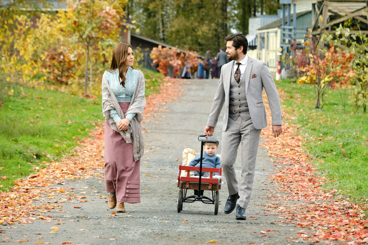 Elizabeth walking next to Lucas, who is pulling Jack in a wagon, in 'When Calls the Heart' Season 9 Episode 11