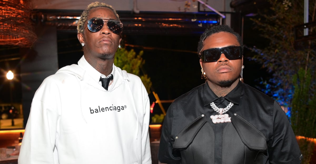 Young Thug and Gunna before their arrests, posing for a photo at a music event in Atlanta, wearing sunglasses and designer clothes.