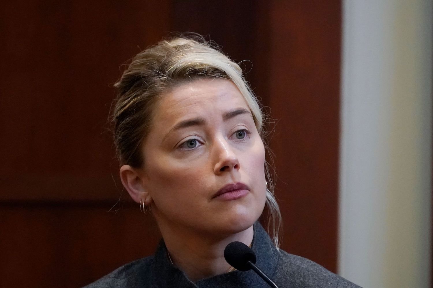 Amber Heard wears a gray suit while on the stand during cross-examination at Johnny Depp defamation trial