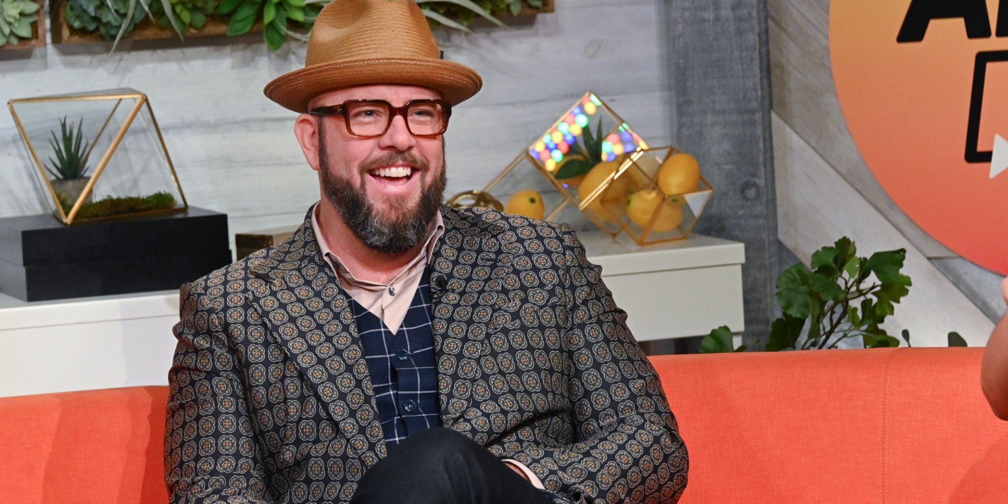 'This Is Us' star Chris Sullivan poses for a photo wearing a hat and checkered coat.