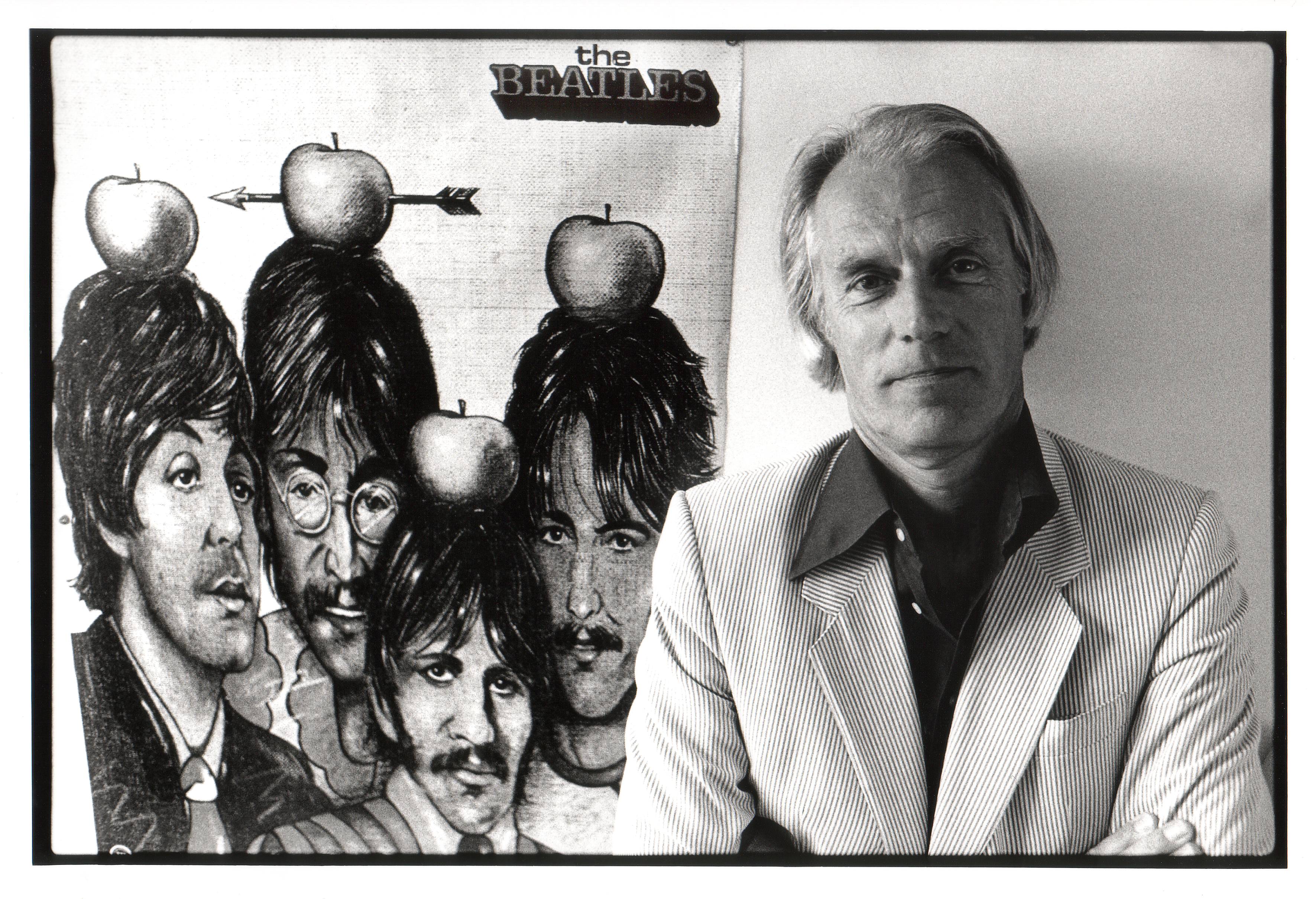 George Martin with a poster of The Beatles
