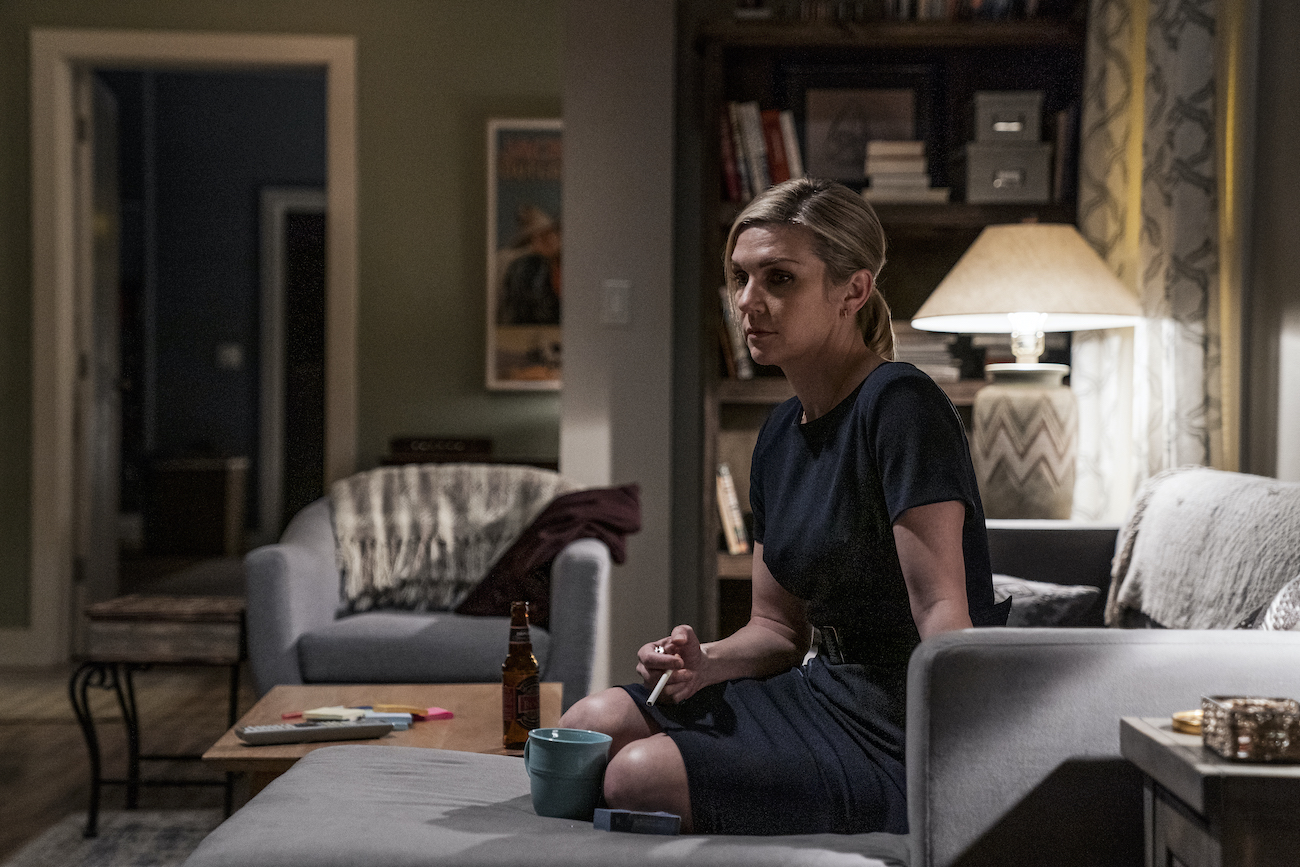 Kim Wexler (Rhea Seehorn) smokes a cigarette on the couch in an episode of 'Better Call Saul'