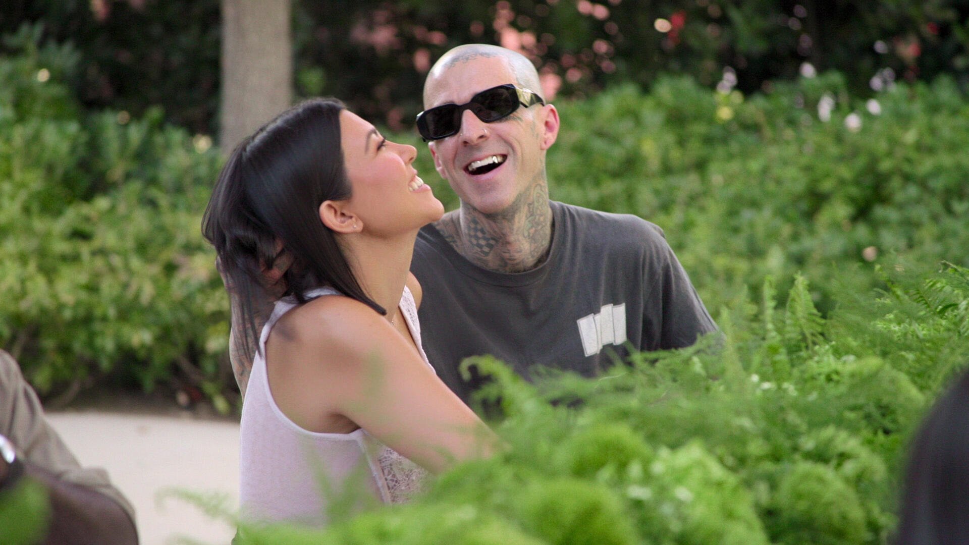 Kourtney Kardashian and Travis Barker smiling together in an episode of 'The Kardashians'