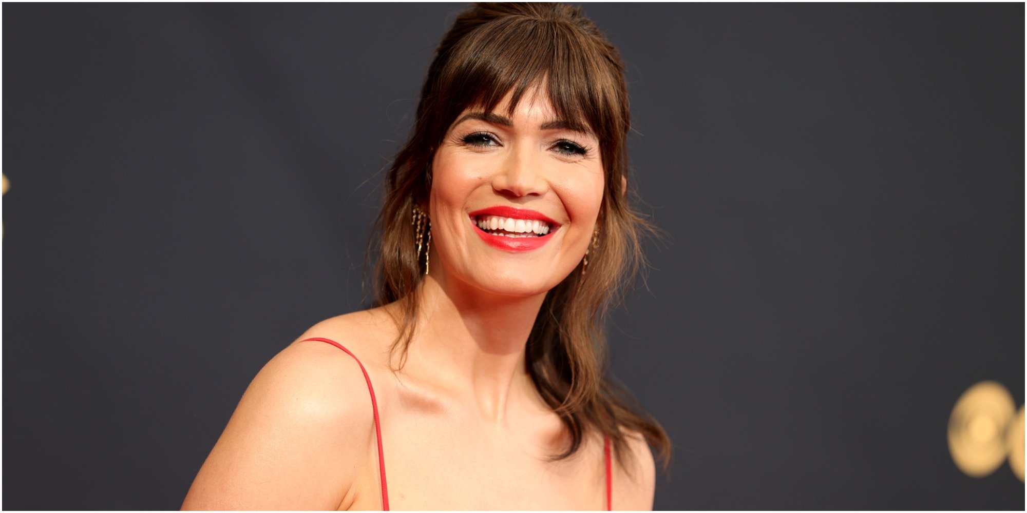 Mandy Moore wears a red dress on the red carpet at the 2021 Emmy Awards.