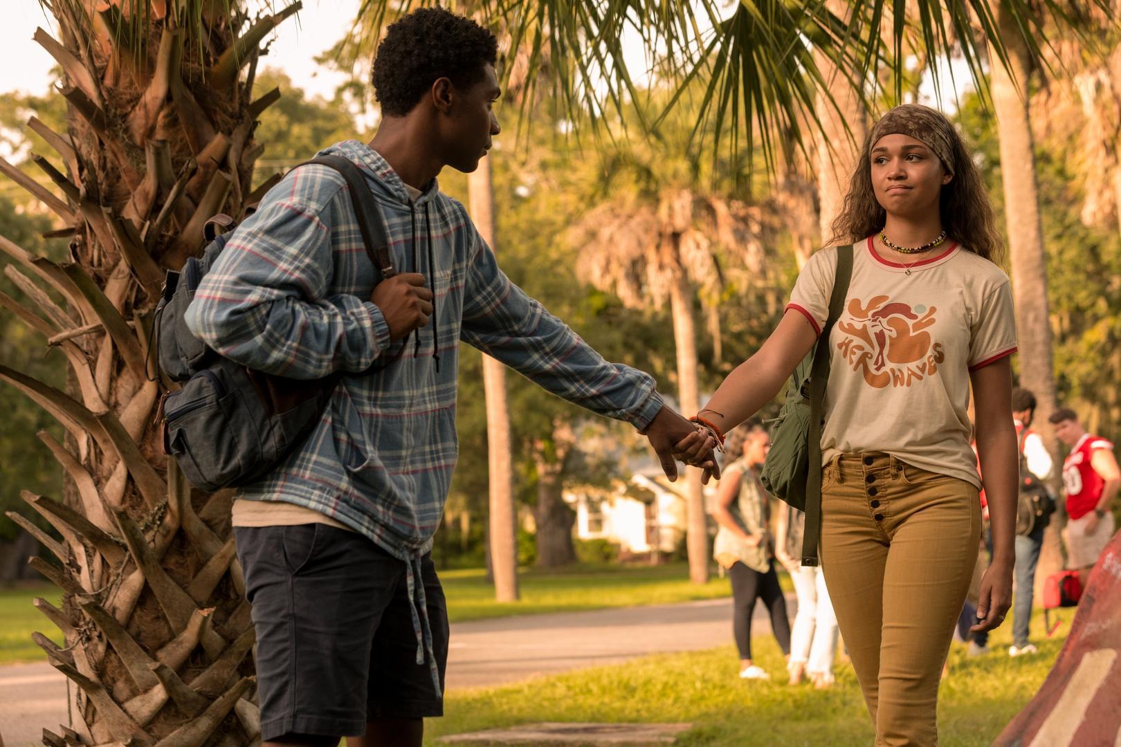 Pope (Jonathan Daviss) and Kiara (Madison Bailey) holding hands in 'Outer Banks' on Netflix