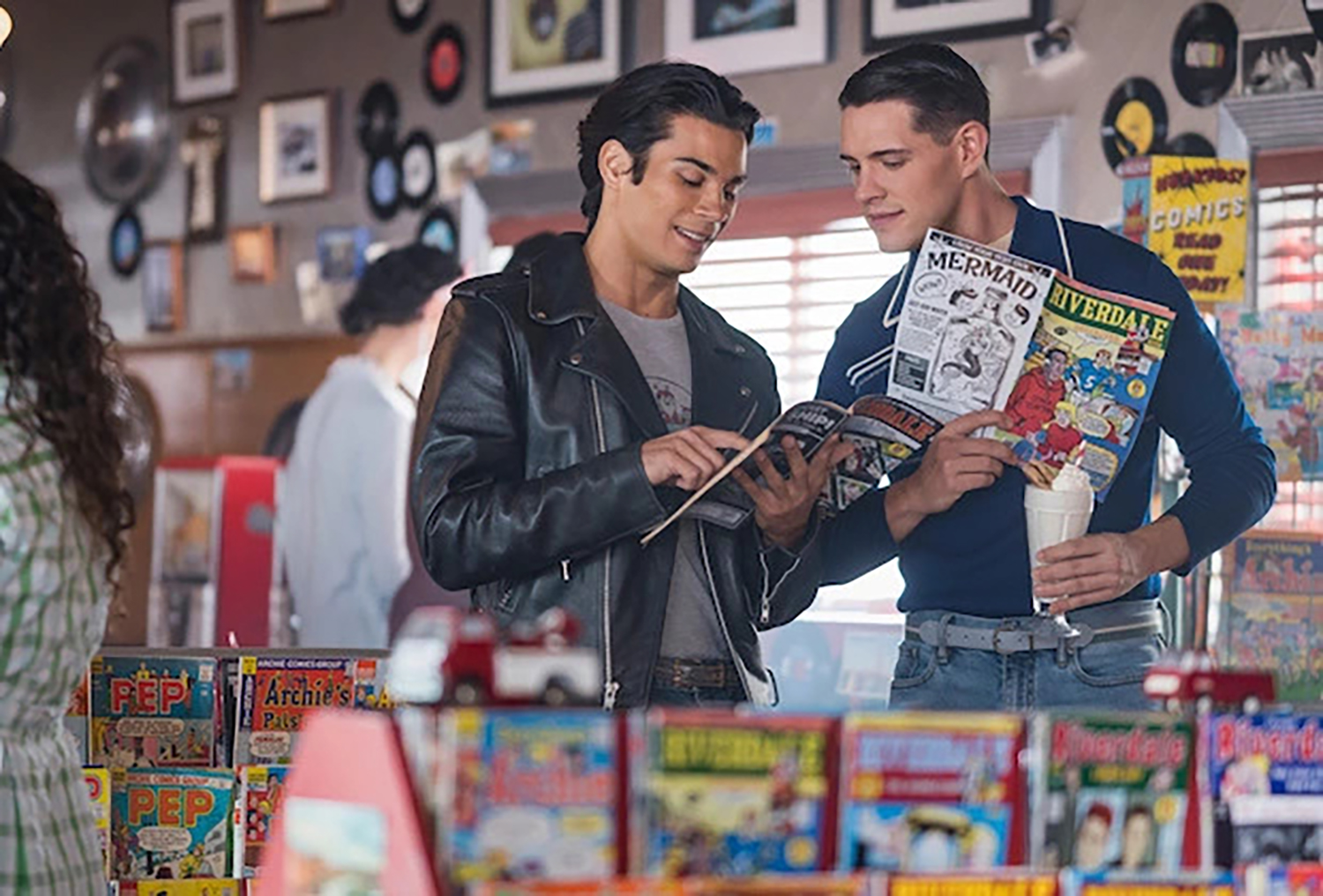 Drew Ray Tanner as Fangs Fogarty and Casey Cott as Kevin Keller reading Archie Comics in Riverdale Episode 100.