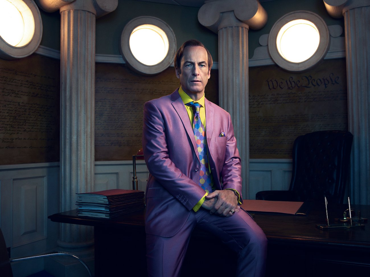 Saul Goodman (Bob Odenkirk) sits on the desk of his office