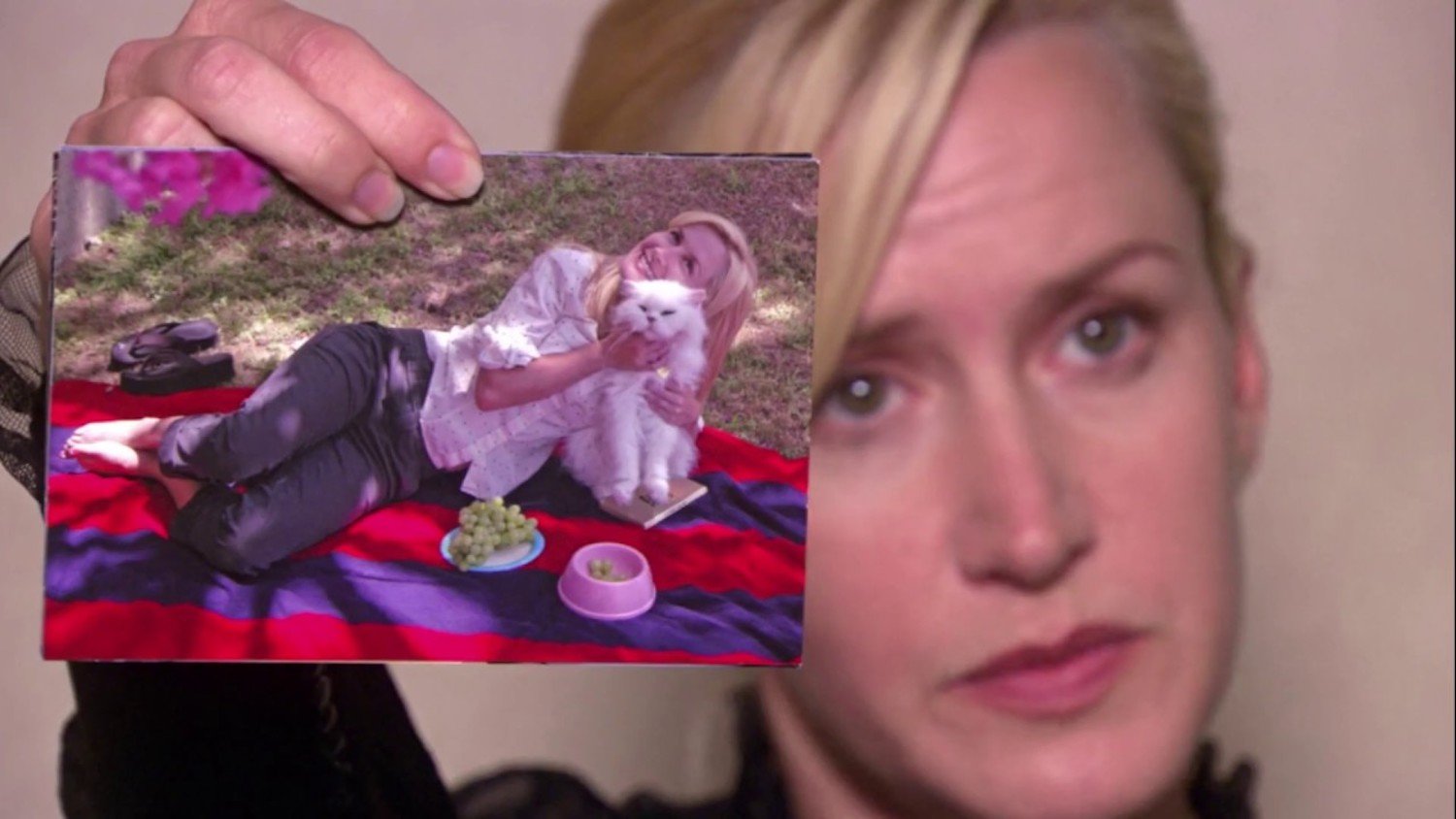Angela Martin (Angela Kinsey) holding a photo of Sprinkles in a talking head from 'The Office'