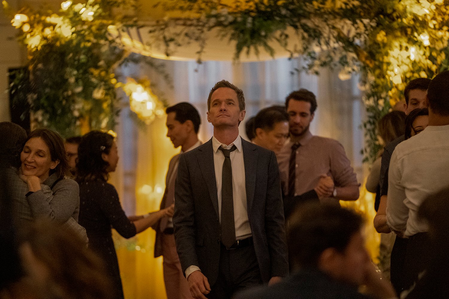Neil Patrick Harris as Michael standing in a crowd in Uncoupled on Netflix.