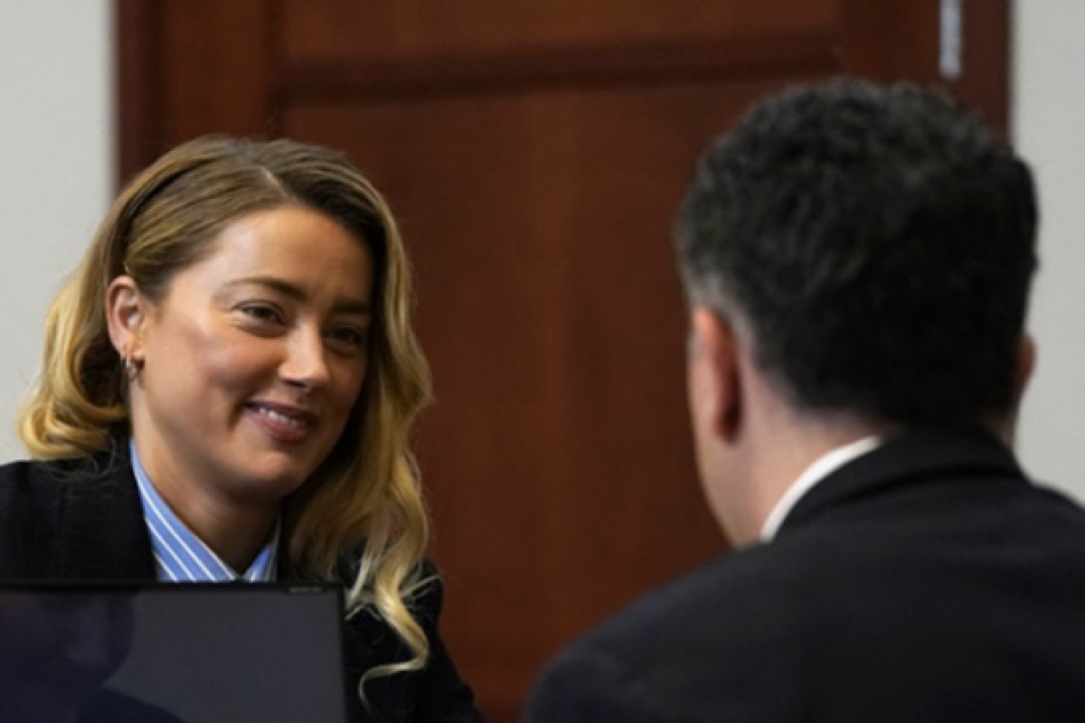 Amber Heard, who recently said she doesn't blame the jury for their defamation trial verdict, smiles at one of her attorneys in court