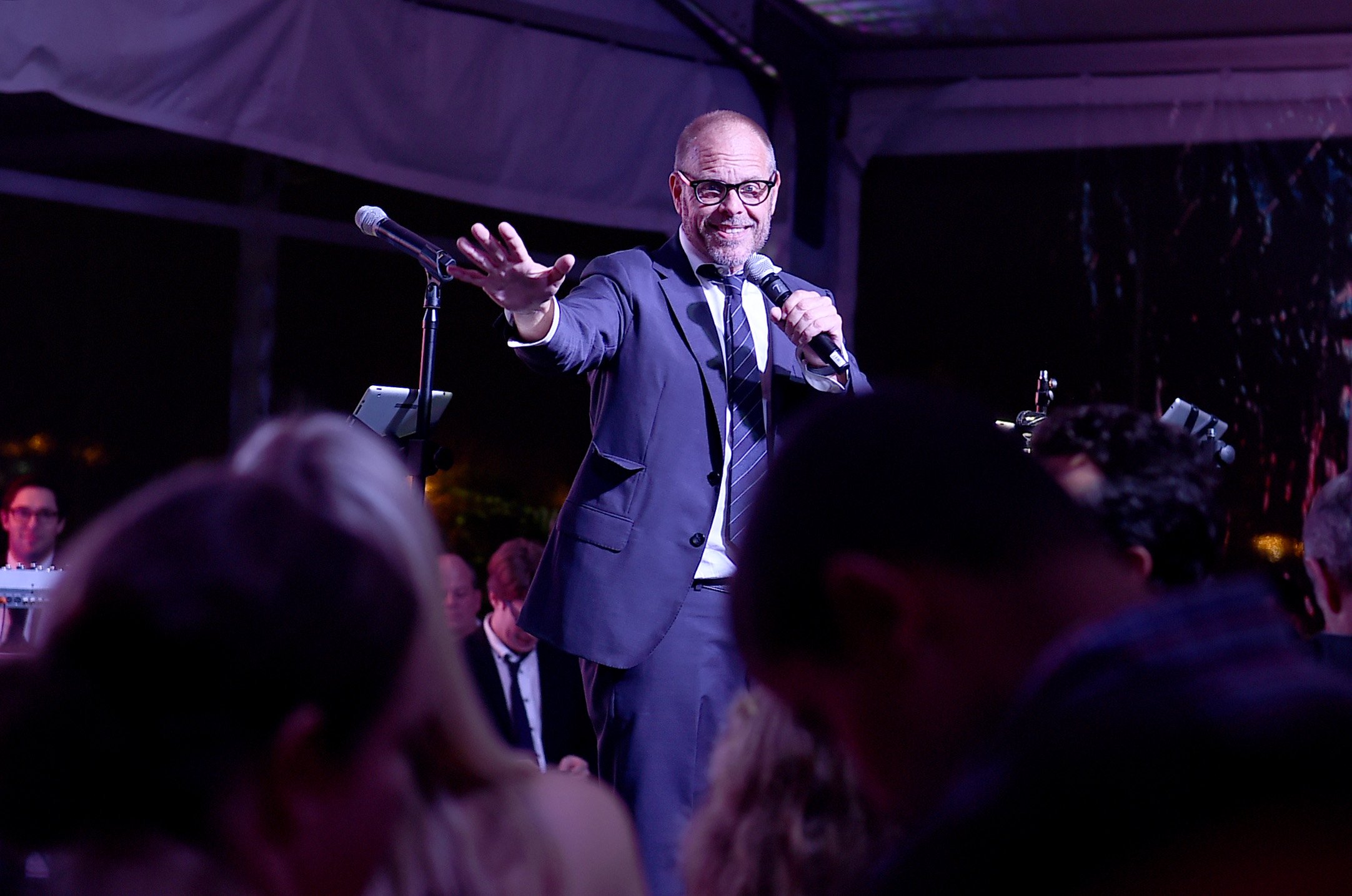 Celebrity chef Alton Brown wears a suit and tie as he addresses an audience in this photograph.