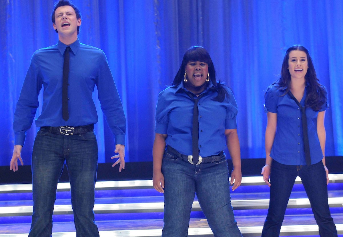 Finn (Cory Monteith), Mercedes (Amber Riley), and Rachel (Lea Michele) perform on an episode of Glee in 2007