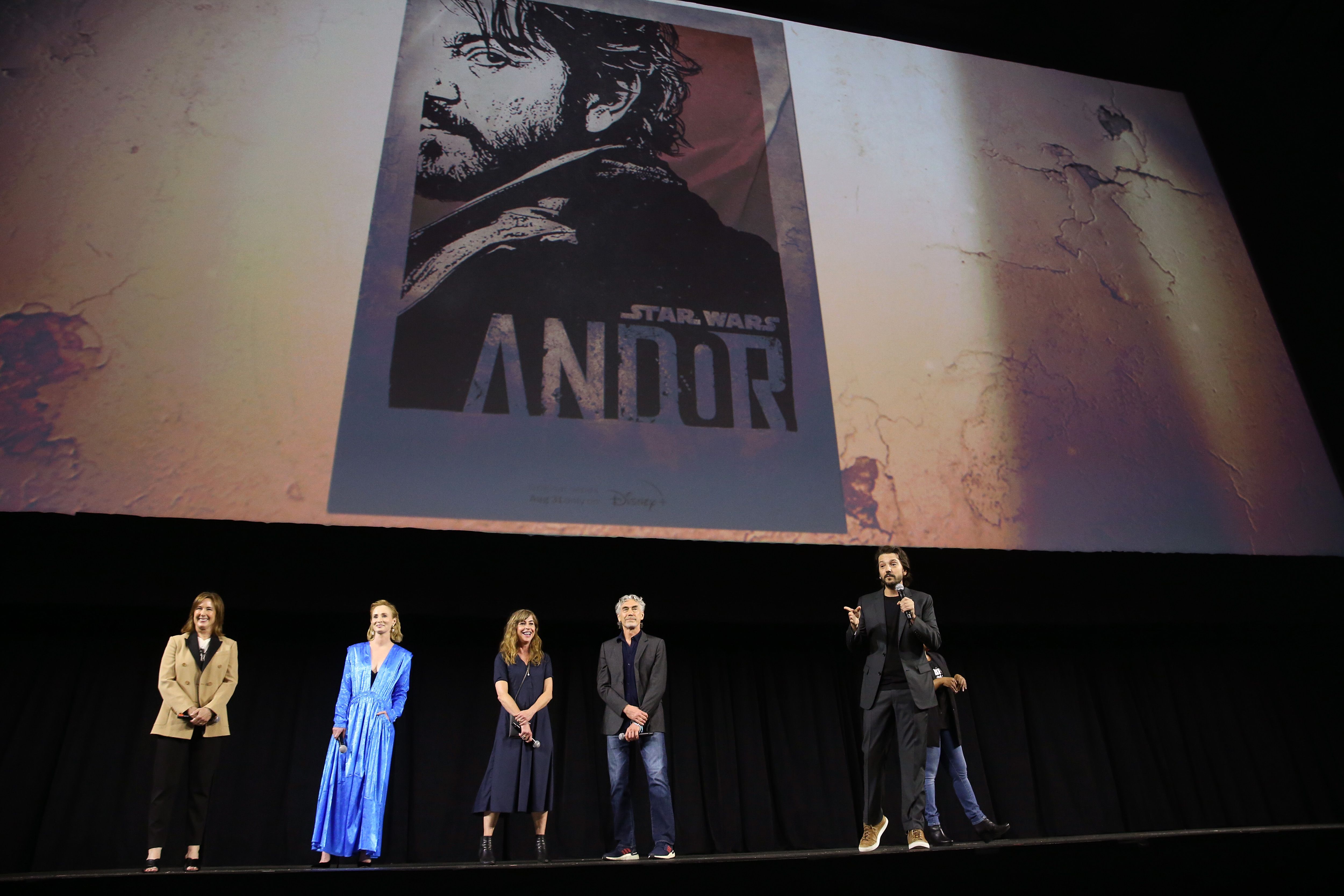 Producers and actors from the 'Star Wars' TV series 'Andor' speak on stage under a promotional image for the show.