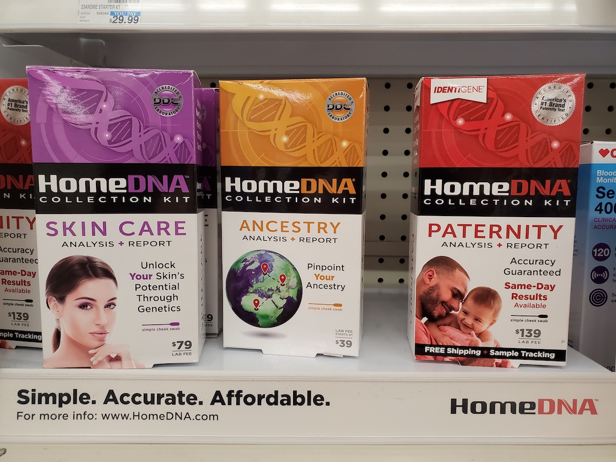 Three at-home DNA tests on a store shelf, including a paternity test