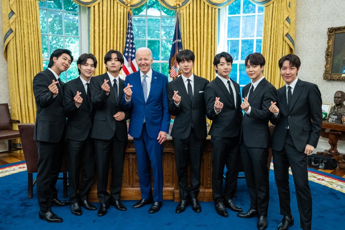 BTS members and President Joe Biden raise their hearts in the Oval Office