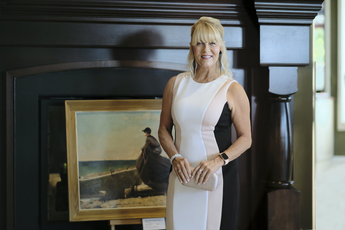 Barbara Niven as Megan O'Brien, standing in front of a painting, in the Hallmark Channel series 'Chesapeake Shores'