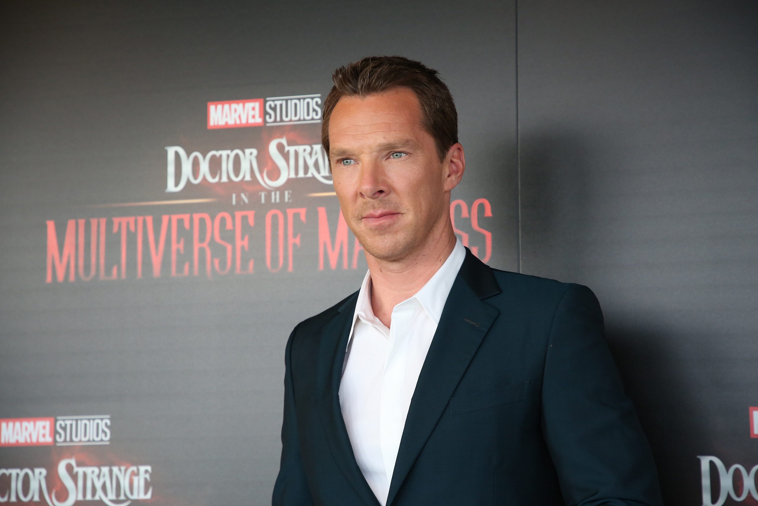 Benedict Cumberbatch, who wants to star in 'Doctor Strange 3,' wears a black suit over a white button-up shirt.