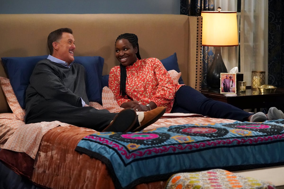 Bob and Abishola sitting on a bed in the CBS sitcom 'Bob Hearts Abishola'
