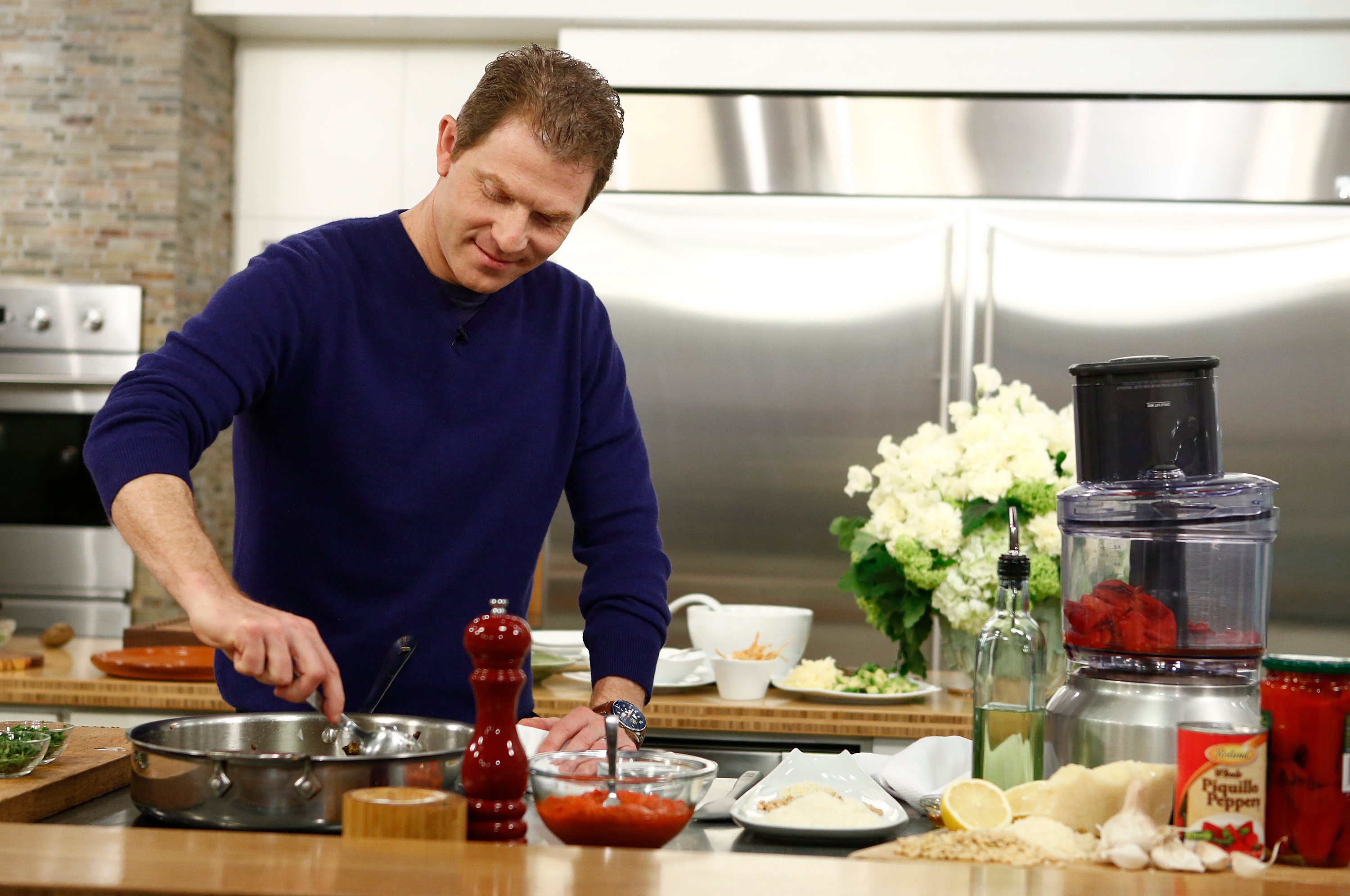 Celebrity chef Bobby Flay wears a blue shirt as he prepares a meal in this photograph.