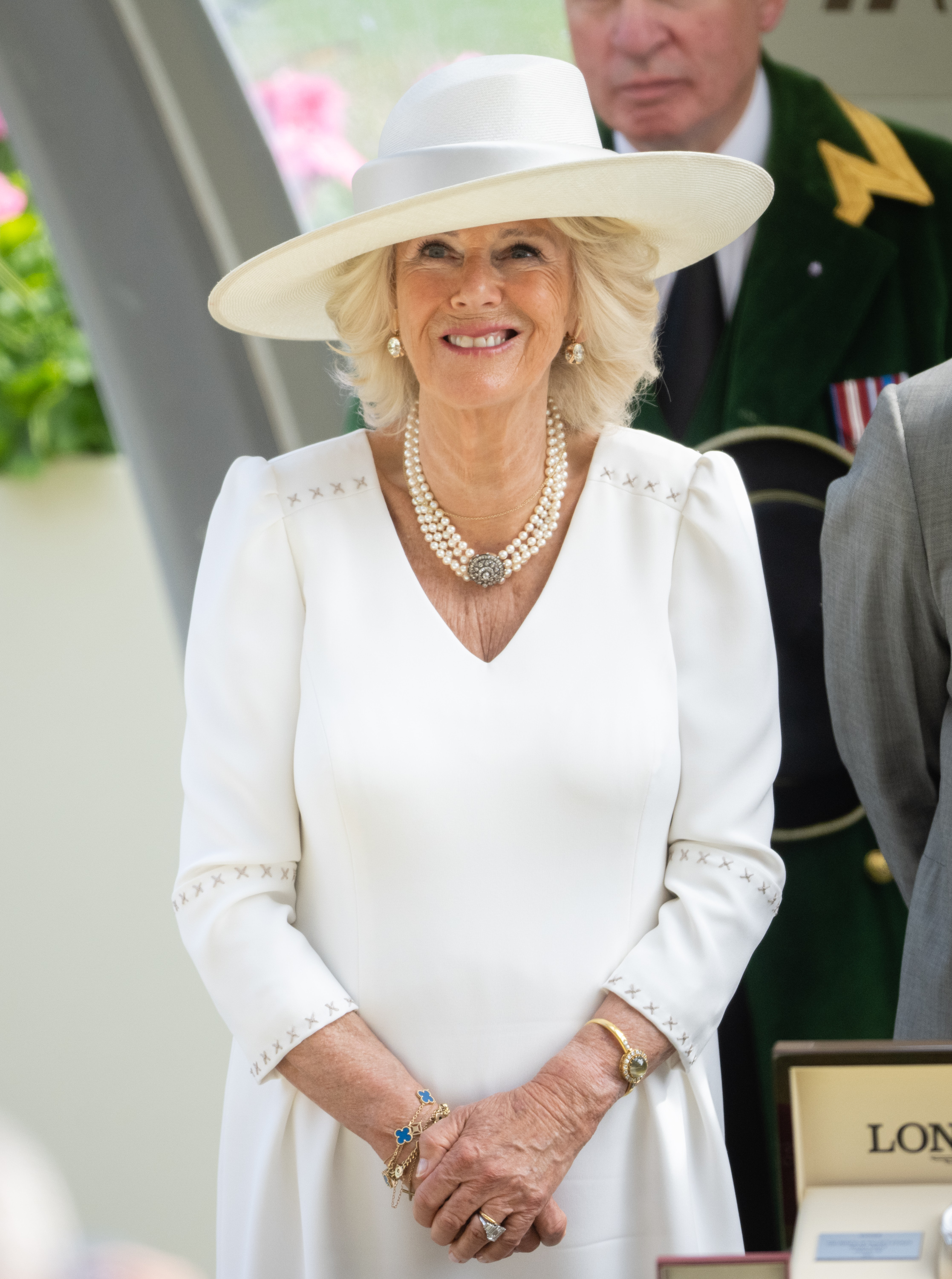 Camilla Parker Bowles stands with her hands clasped in front of her at the Royal Ascot.