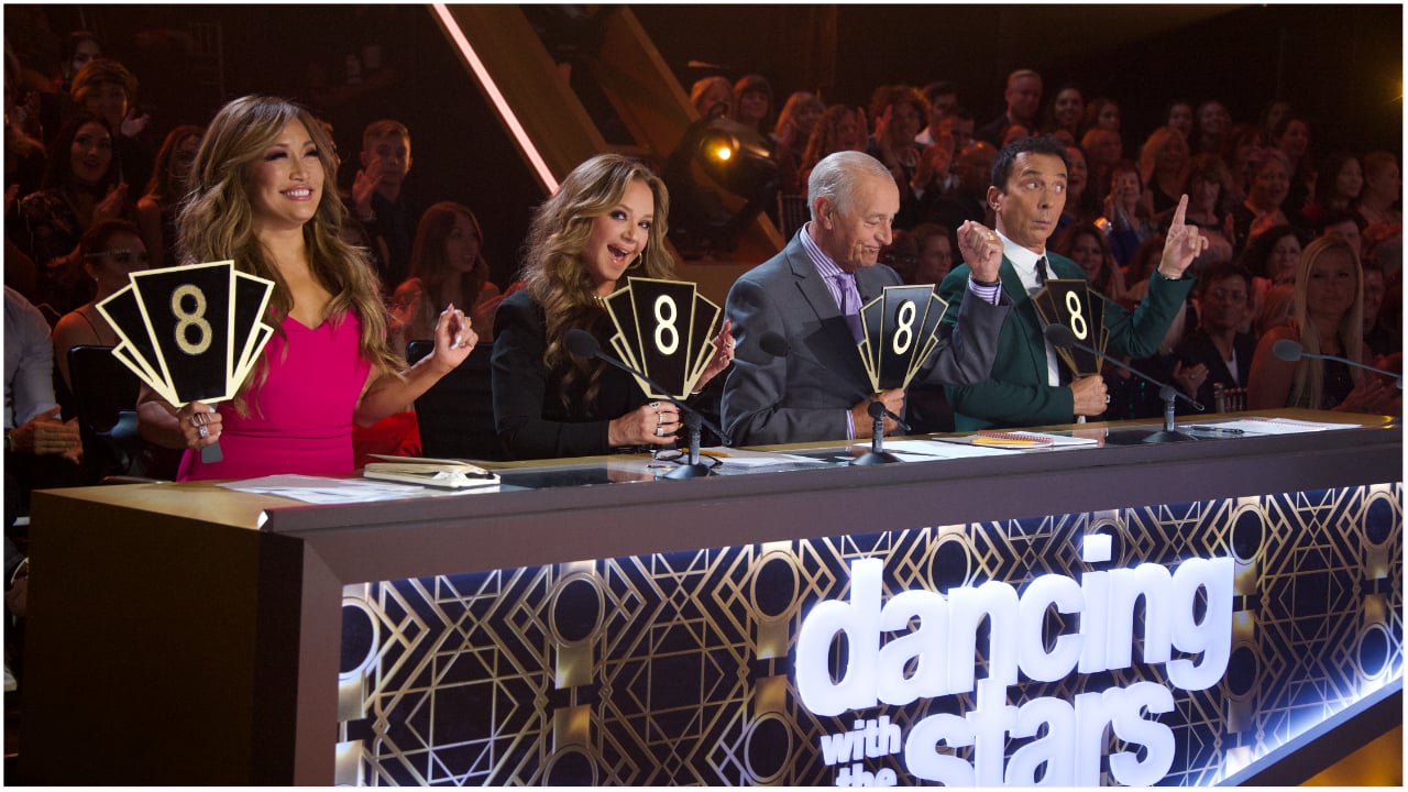 Carrie Ann Inaba, Leah Remini, Len Goodman, and Bruno Tonioli holding up scores at the judging panel of 'Dancing with the Stars'