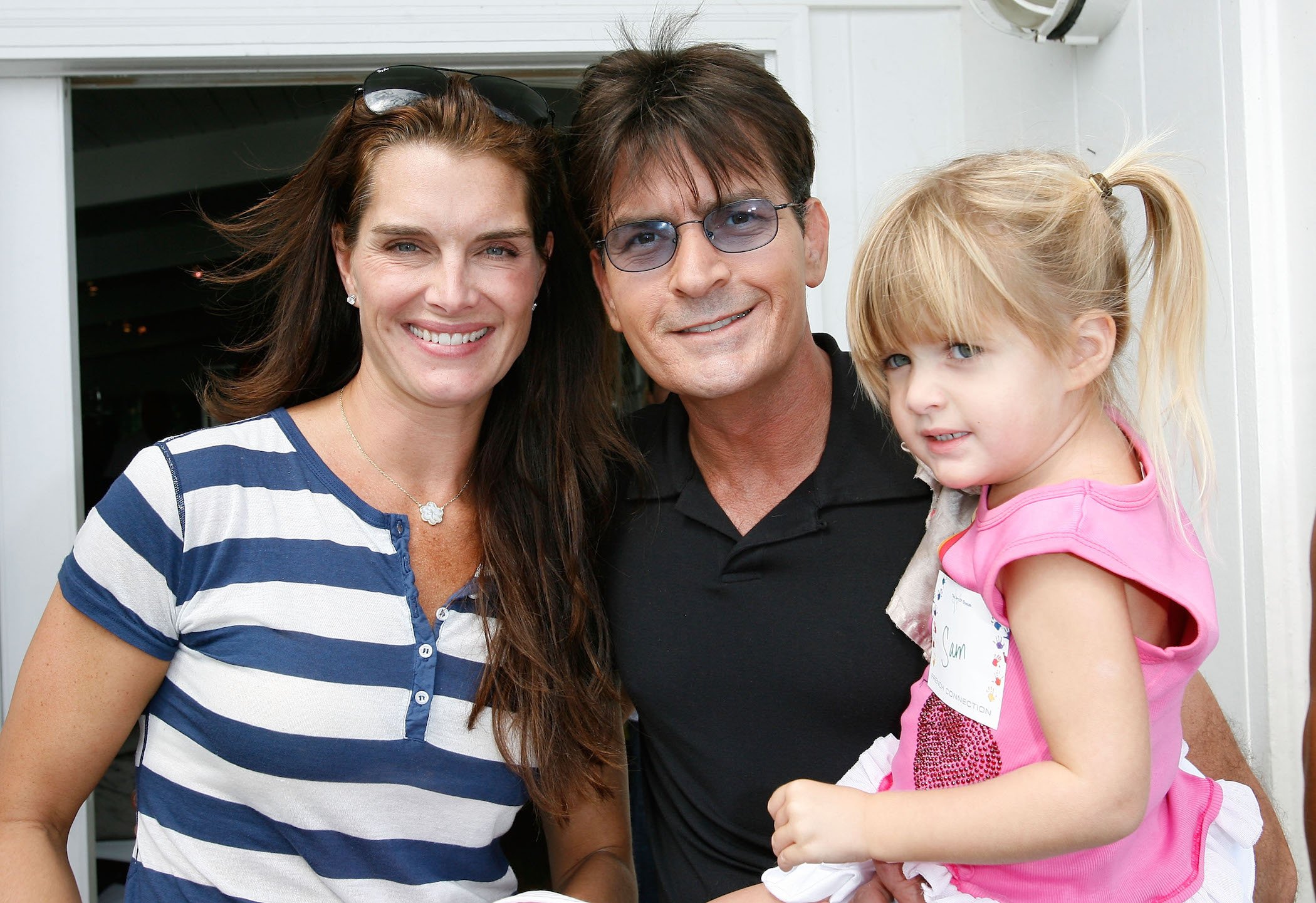 Brooke Shields, Charlie Sheen, and a young Sami Sheen smiling at an event