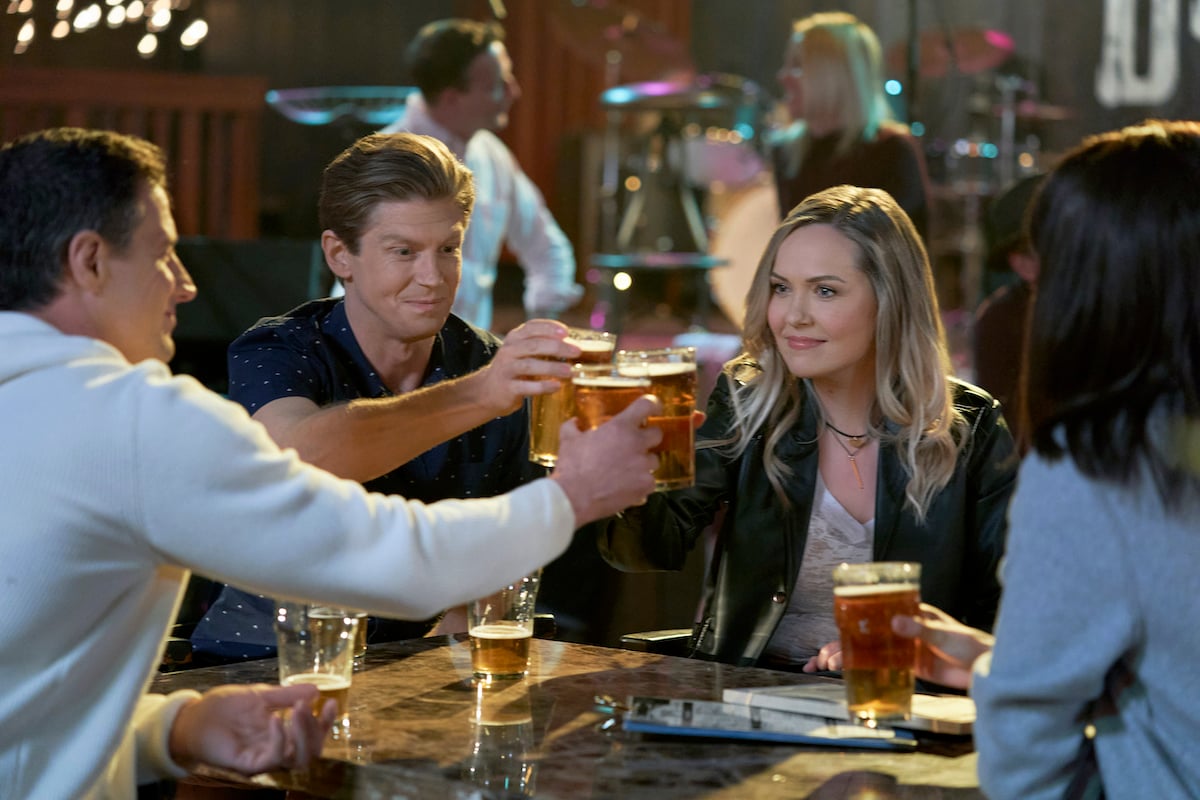 Connor and Bree toasting with glasses of beer in a scene from 'Chesapeake Shores' Season 5 on Hallmark Channel
