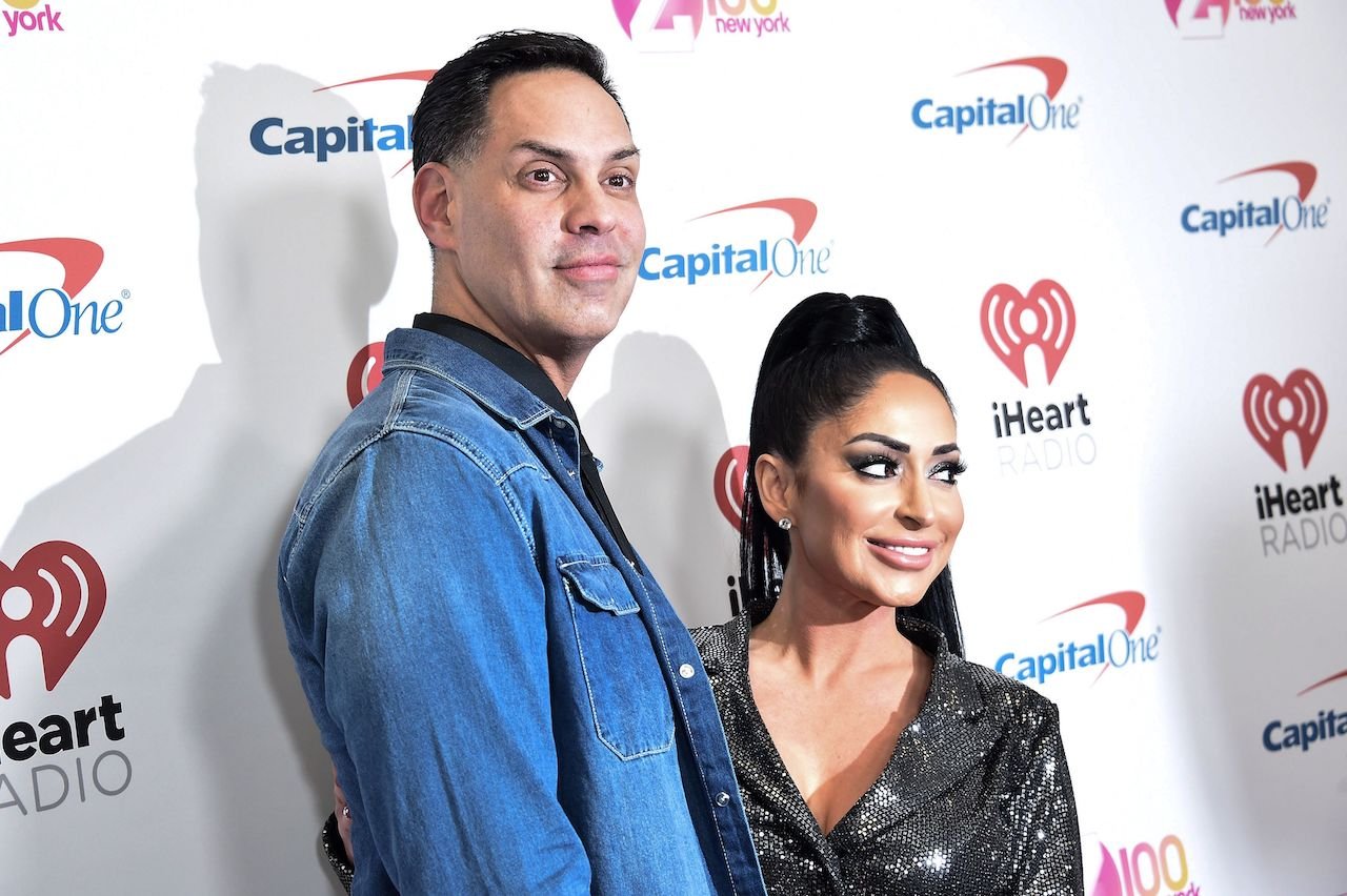 Angelina Pivarnick and husband Chris Larangeira smile posing together on the red carpet.