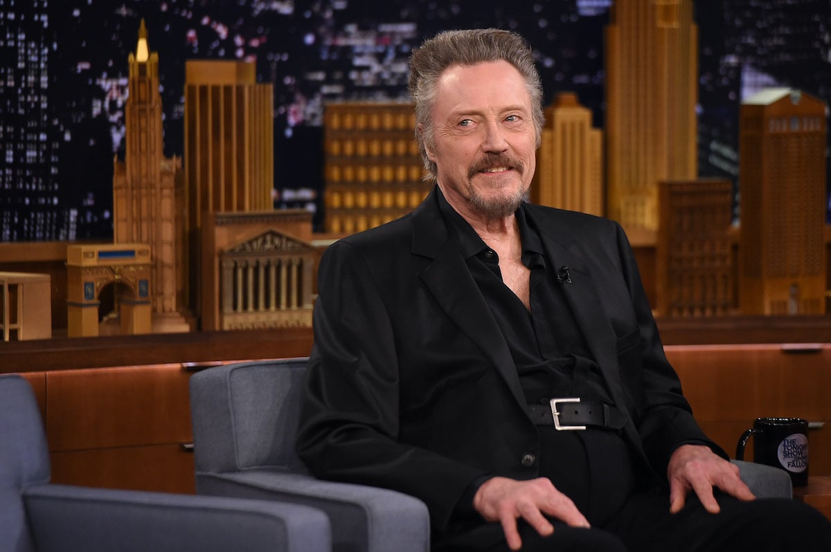 Christopher Walken smiling, sitting down