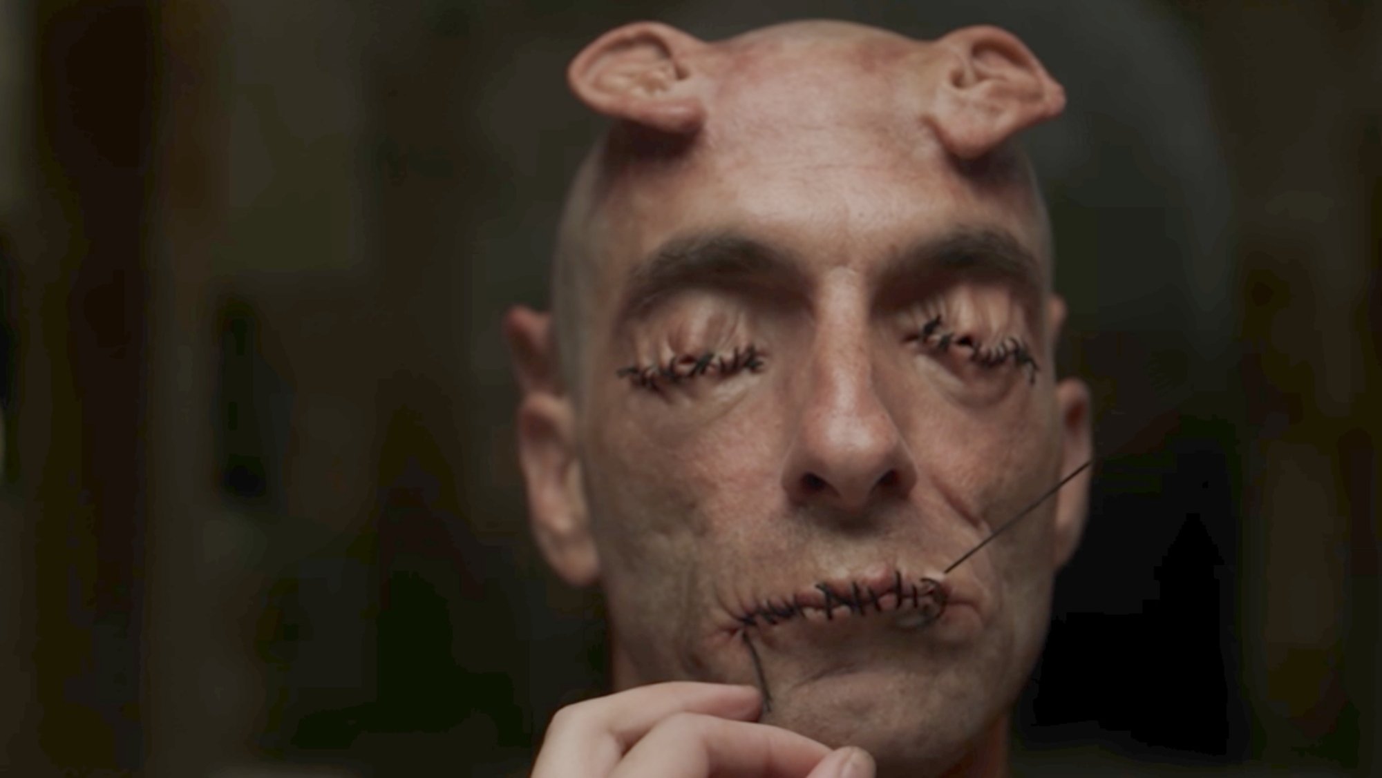 'Crimes of the Future' Tassos Karahalios as Ear Man with his mouth and eyes sewn shut and ears coming out of his head