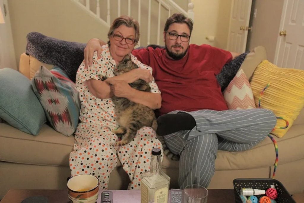 Debbie Johnson and Colt Johnson sit on a couch during filming of '90 Day Fiancé: Pillow Talk' on TLC.