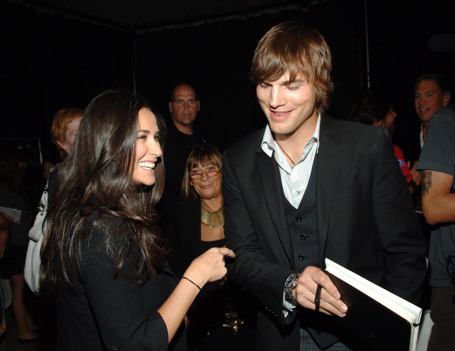 Ashton Kutcher and Demi Moore laughing together at an event
