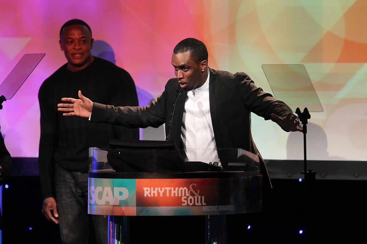 Diddy speaking on stage with Dr. Dre standing behind him.