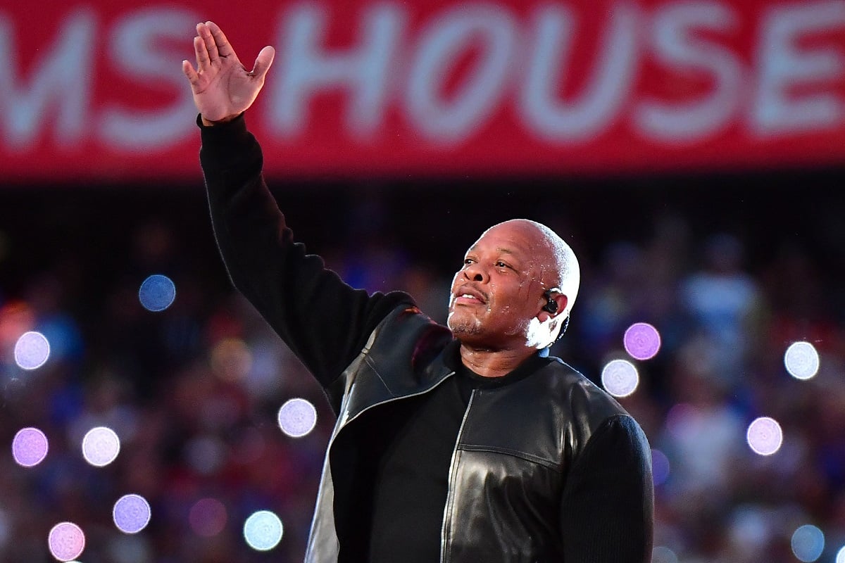 Dr. Dre performing on stage while wearing black clothes.