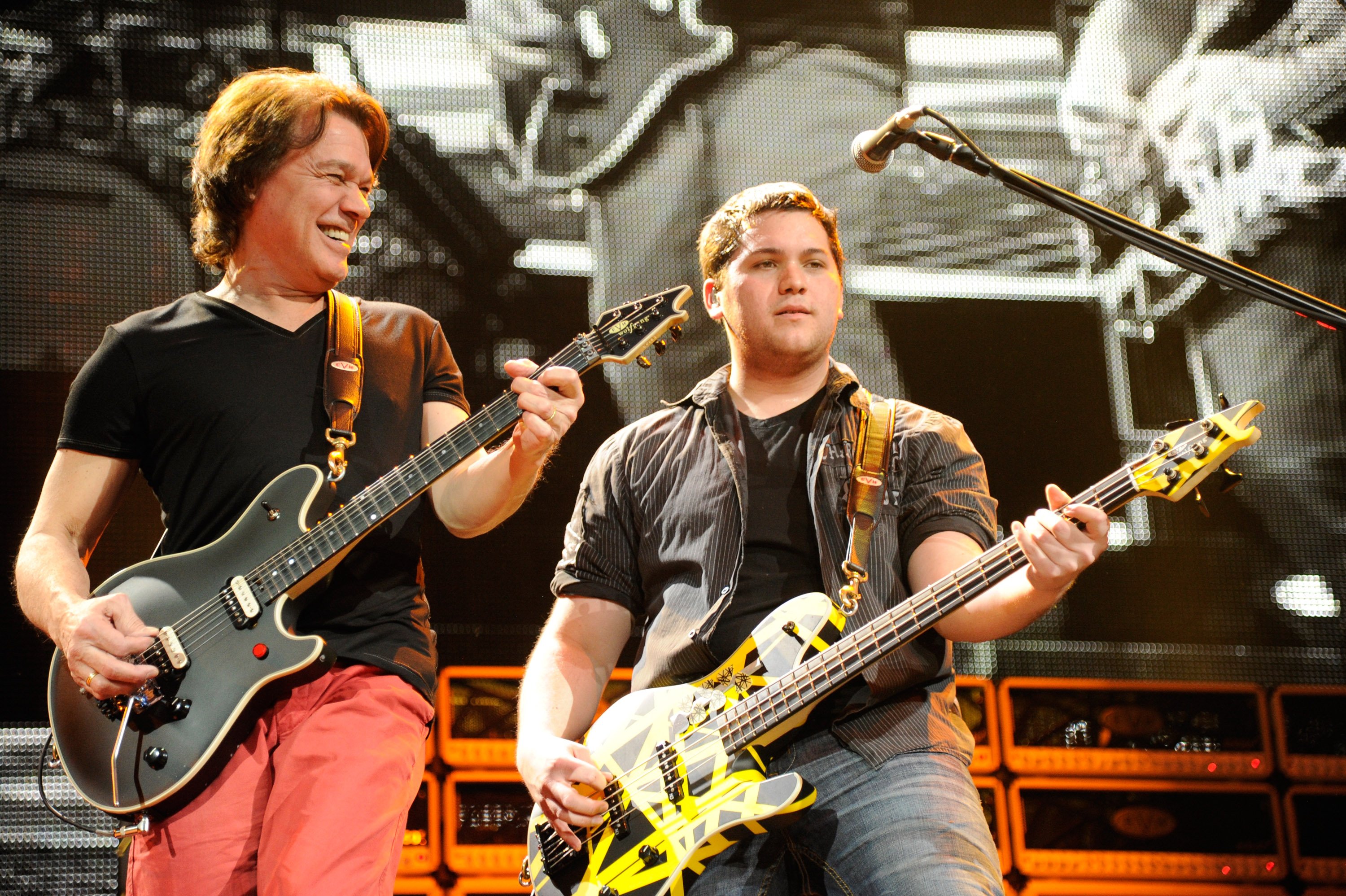 Eddie Van Halen next to his son Wolfgang Van Halen, both playing guitar