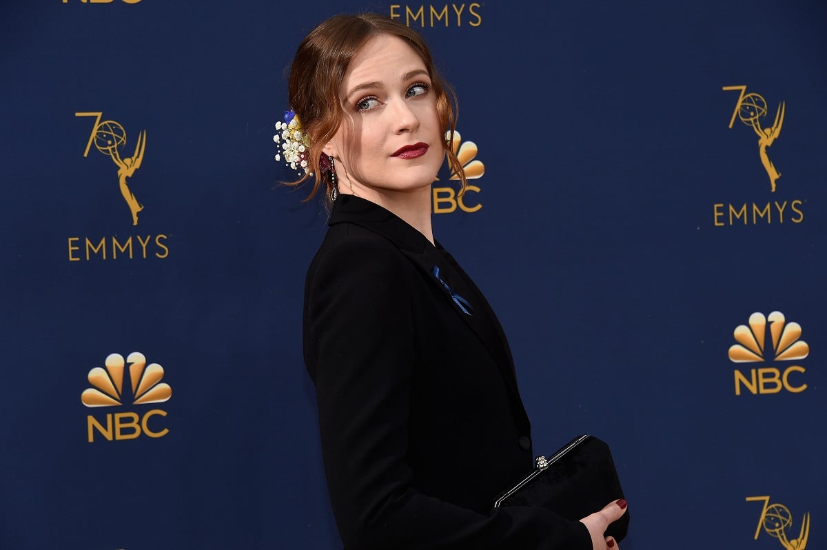 Evan Rachel Wood posing while wearing a black dress and lipstick.