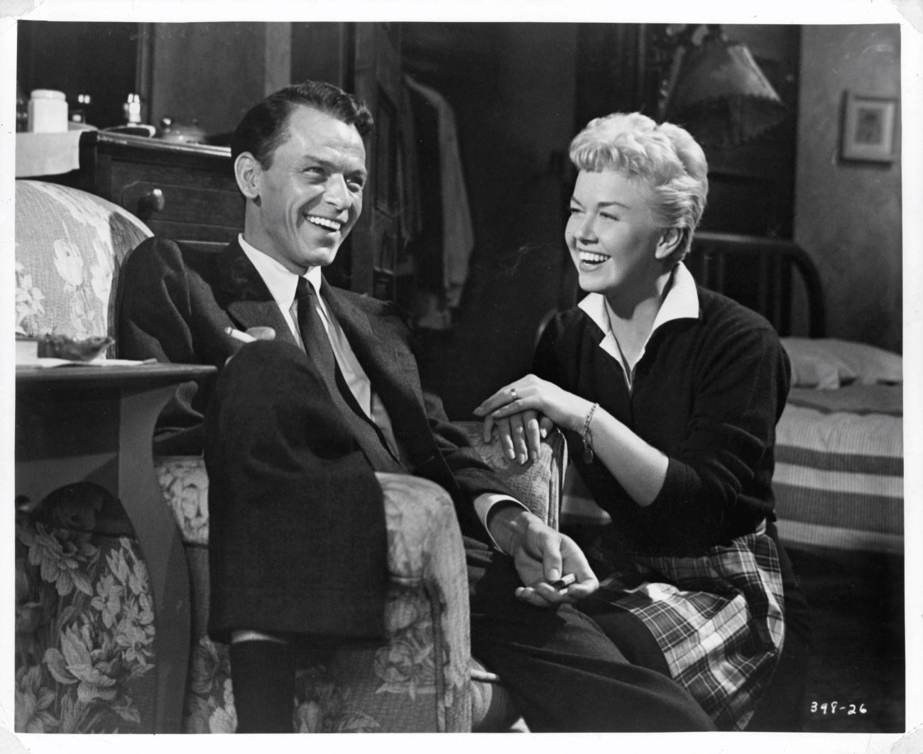 A black and white picture of Frank Sinatra sitting in an arm chair and Doris Day sitting next to him.