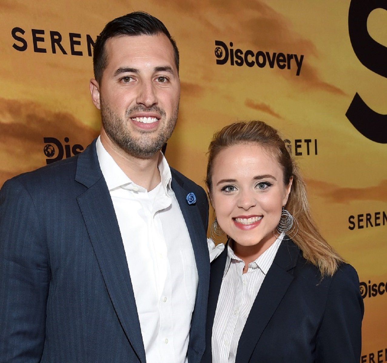 Jinger and Jeremy Vuolo posing together at the premiere of Discovery's 'Serengeti' in 2019, both wearing suits