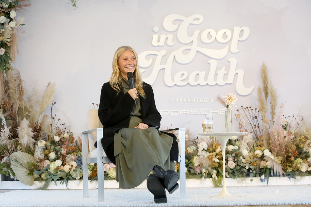 Gwyneth Paltrow sitting on a chair talking on a microphone.