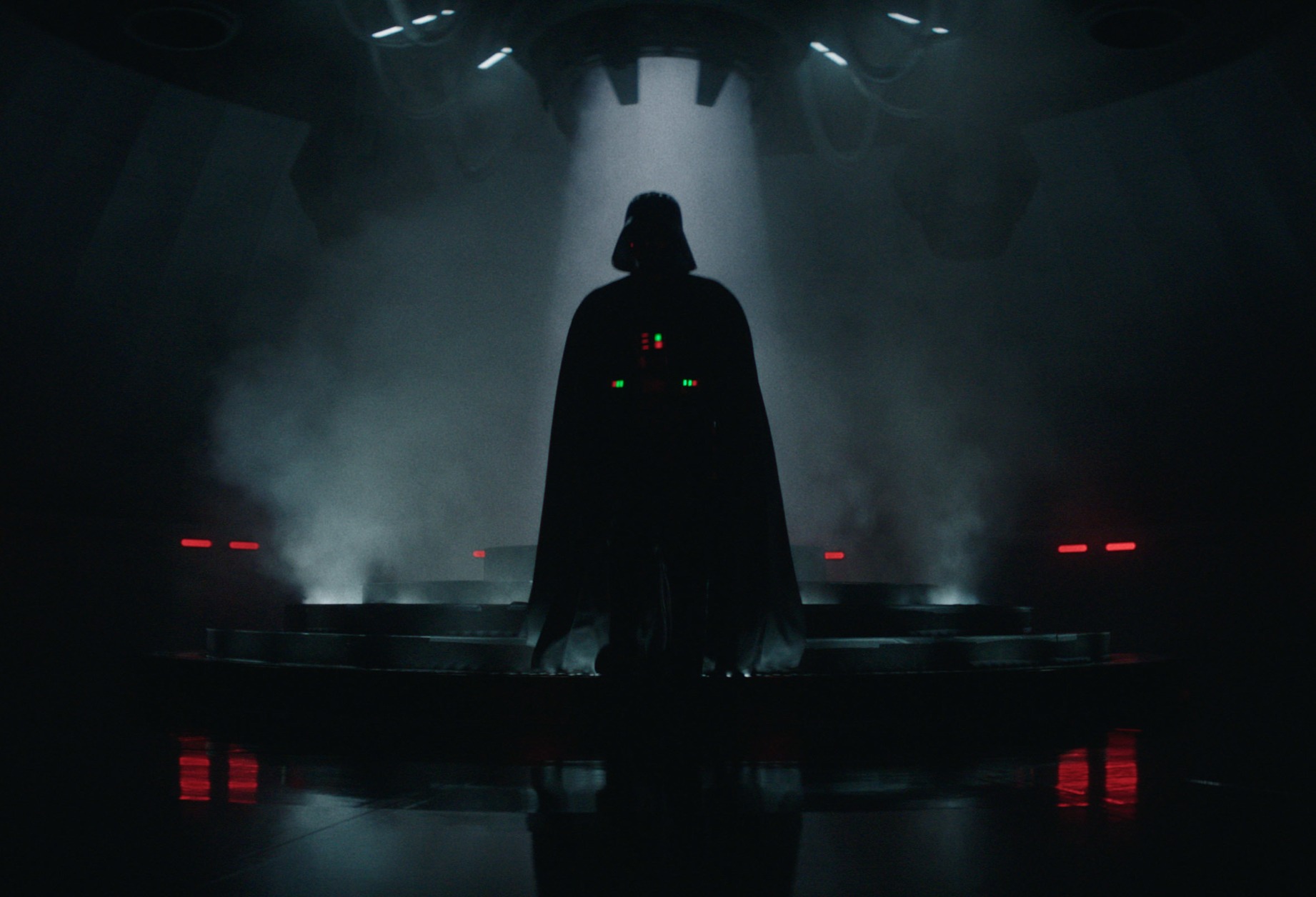 Hayden Christensen as Darth Vader in 'Obi-Wan Kenobi' Episode 3. He's wearing the Darth Vader suit and standing beneath a light.