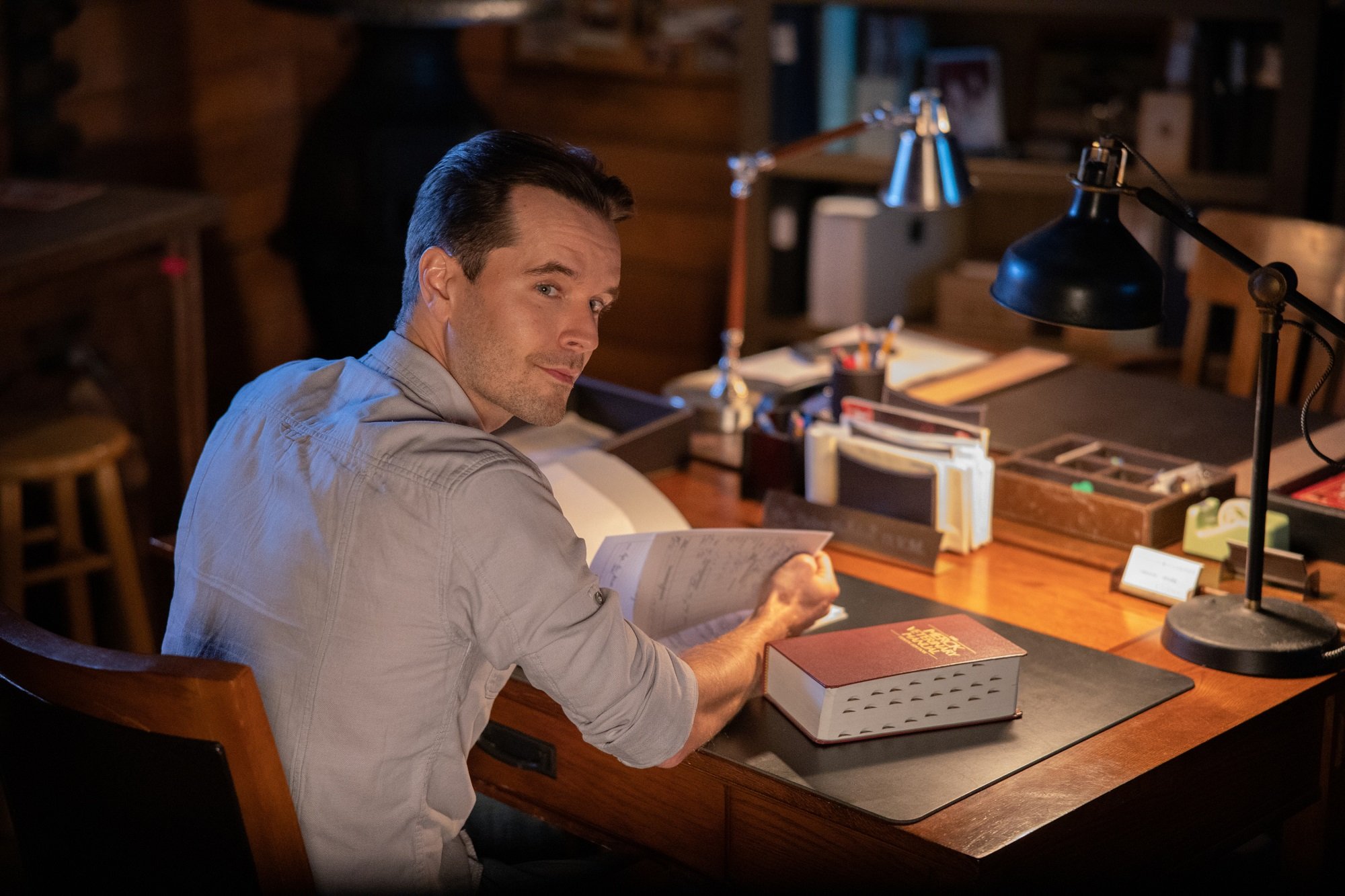 Ty sits at a desk and looks over his shoulder in 'Heartland'