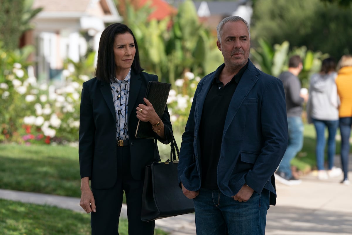Mimi Rogers as Honey Chandler holding a black purse standing next to Titus Welliver as Harry Bosch in 'Bosch: Legacy' Season 1