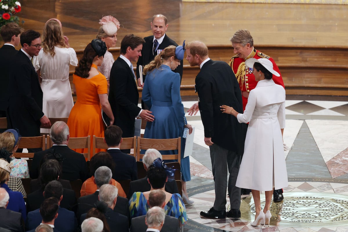 Princesses Eugenie and Beatrice, and their husbands, stand to let Prince Harry and Meghan Markle by during the Platinum Jubilee weekend National Service of Thanksgiving 